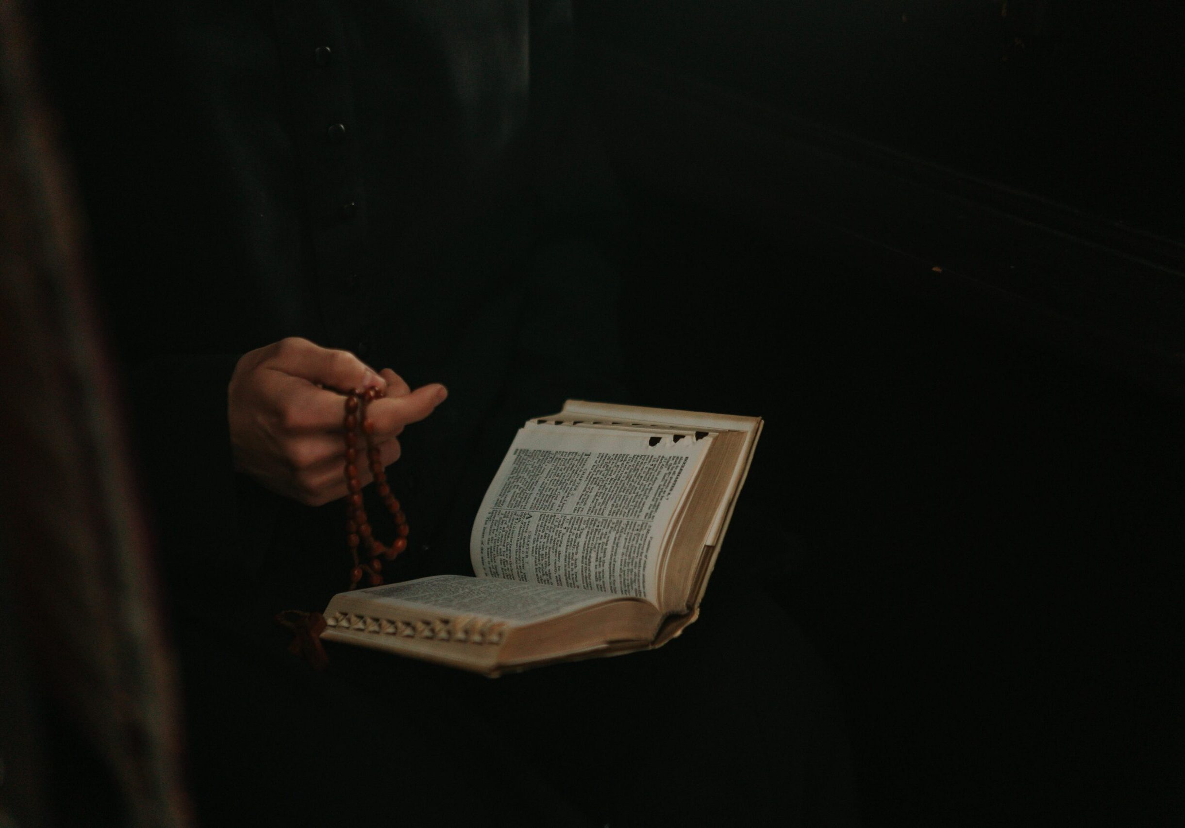 person-holding-rosary-and-bible